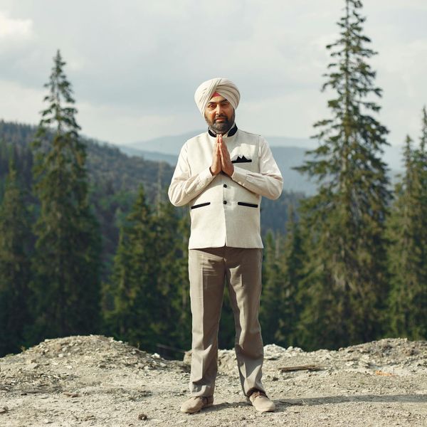 Person meditating peacefully outdoors with a natural green background.